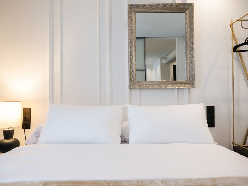Apartamento Premium con balcón | Dormitorio Cama doble con ropa de cama blanca, espejo de marco plateado y lámpara de mesilla