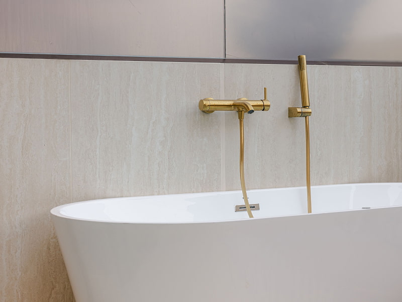 Penthouse with hot tub | Jacuzzi Bañera de hidromasaje blanca con grifería dorada junto a una pared de madera clara