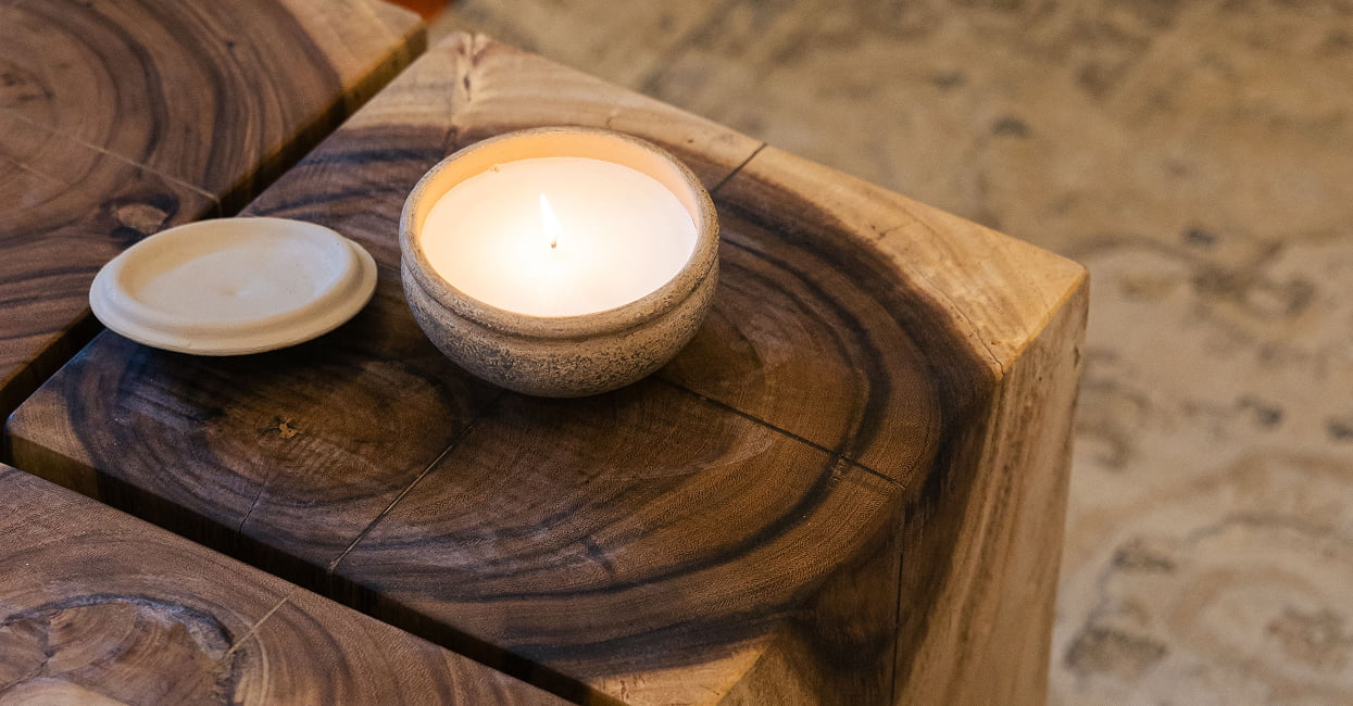 Detalles de decoración Vela encendida y platillo sobre una mesa de madera maciza