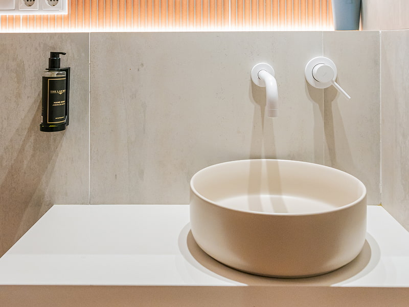 Apartamento 1 habitación | Lavabo Lavabo redondo color crema con grifería blanca de pared y dispensador de jabón negro