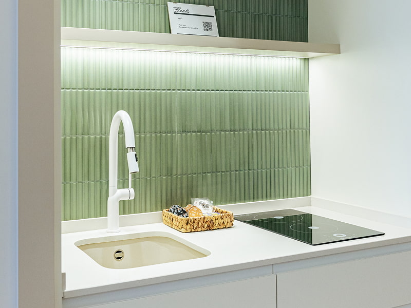 Apartamento 2 habitaciones | Cocina Cocina con azulejos verdes, grifo blanco, fregadero y placa de inducción
