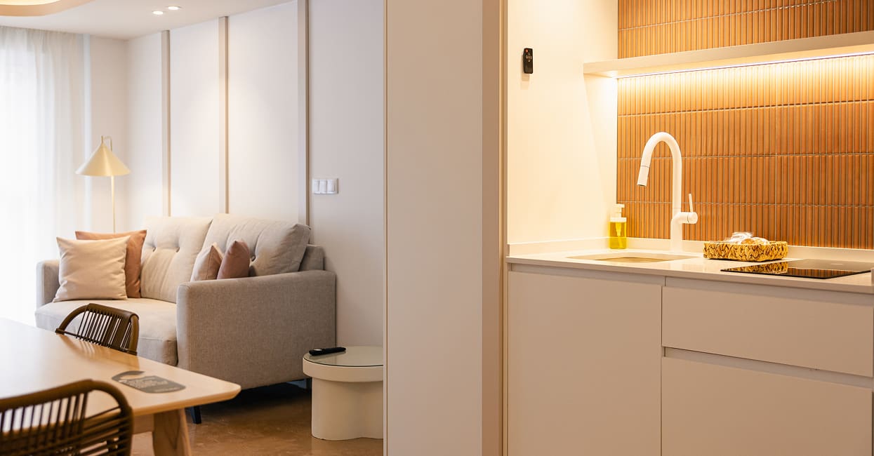 Salón con cocina abierta Salón con sofá y cocina abierta con azulejos terracota y luz cálida
